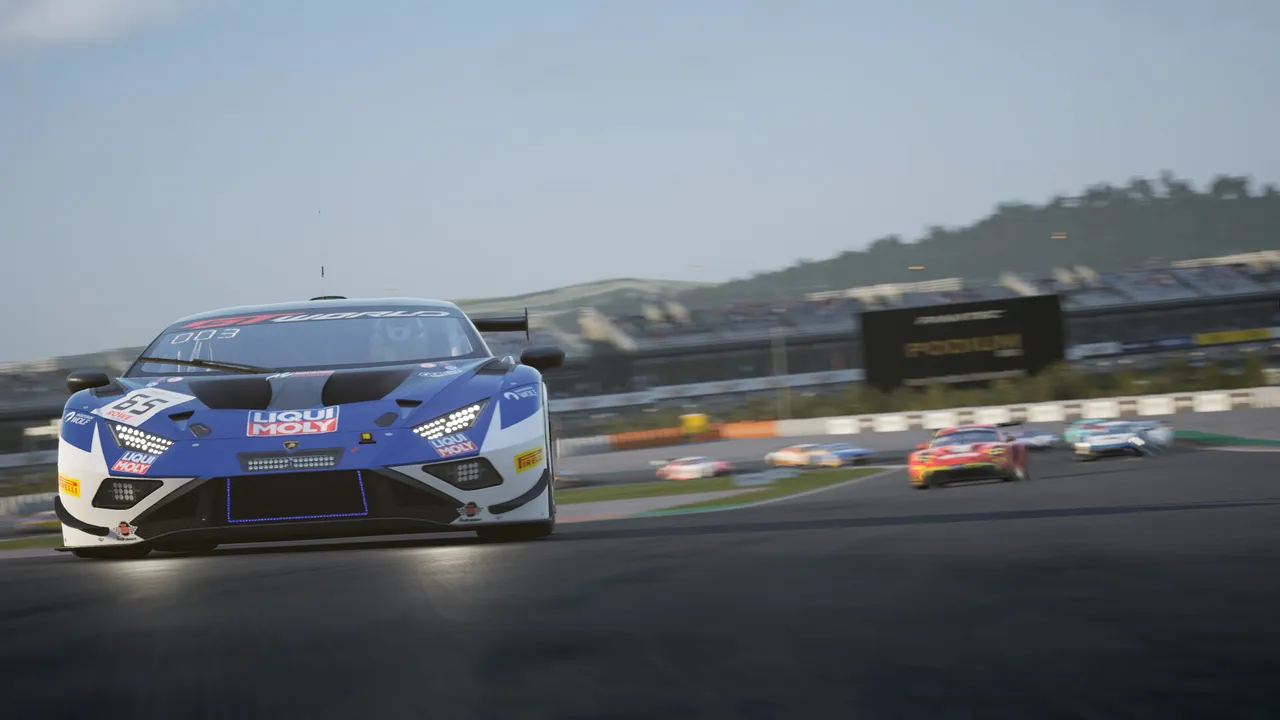 Vettura GT3 blu e bianca in testa a un gruppo di concorrenti in uscita di curva, con tribune e cartelloni sullo sfondo